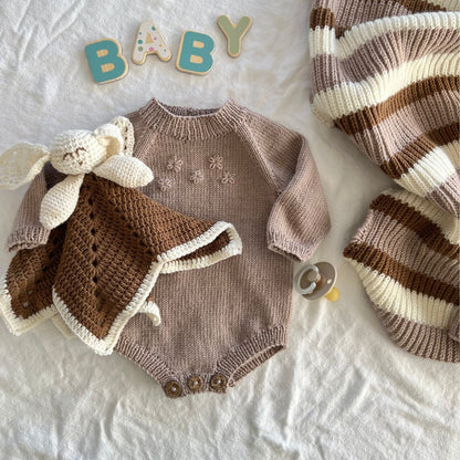 Strikket blomsterbody med koseklut og yndlingspledd – strikke babygarderoben i 100% kløfri merinoull. Lettstrikket body som perfekt første babystrikk – strikkepakke blomsterbody med enkel strikkeoppskrift. Body er det mest brukte babyplagget – nybegynnervennlig babystrikk.