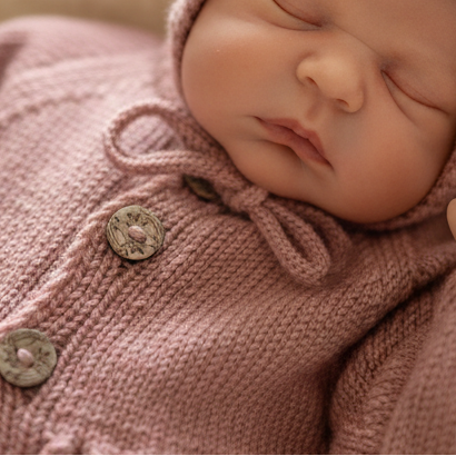 Baby i rosa strikket Vesleskattens eventyrjakke, jakke med hullmønster. strikke baby jakke
