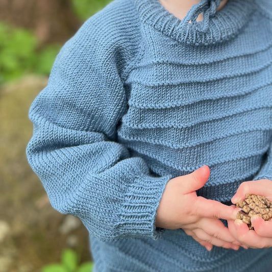 Detaljer på drømmegenser i 100% kløfri merinoull – nydelig rillemønster på genser og lue. Strikkepakke drømmesett til baby og barn 0–3 år, perfekt for aktive barnehagebarn. Godt som eneste ytterplagg på høst og vår.