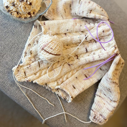 Vesleskattens flettebody på pinnene – strikkepakke baby body i håndfarget eksklusivt Unikt Garn med flettemønster. Størrelser fra nyfødt til 2,5 år, elastisk hals og knapper mellom beina for enkelt bleiebytt.