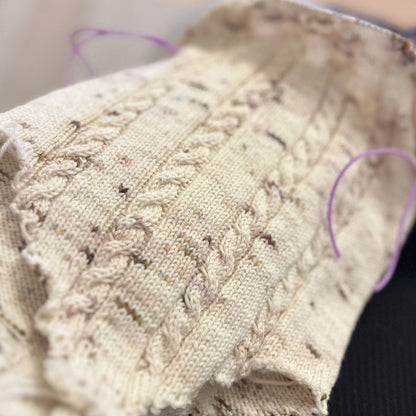 Vesleskattens flettebody på pinnene – detaljer på flettemønster. Strikkepakke baby body i håndfarget eksklusivt Unikt Garn, størrelser nyfødt til 2,5 år. Enkel av og påkledning.