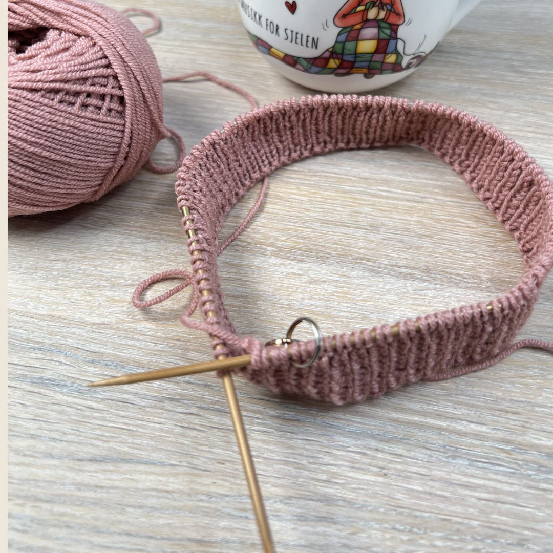 Strikke hentesett selv – hentesett på pinnene i kløfri merinoull. Strikkepakke hentesett til baby med hullmønster i Dale Garn Soft Merino. Strikke hentesett til jente i 100% merinoull.