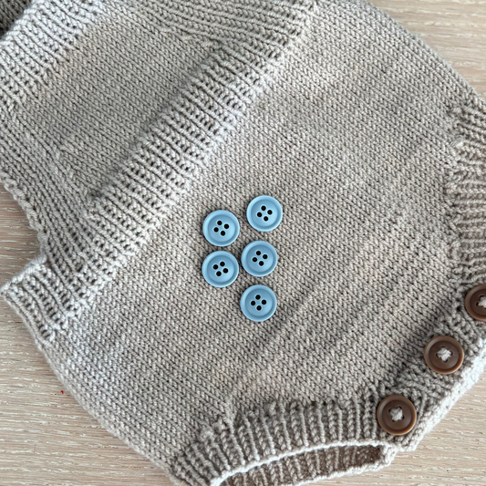 Lyseblå knapp til babystrikk i størrelse 15 mm fra merket Go Handmade. Knapper som tåler mye og passer perfekt til strikkeplagg til baby og småbarn.