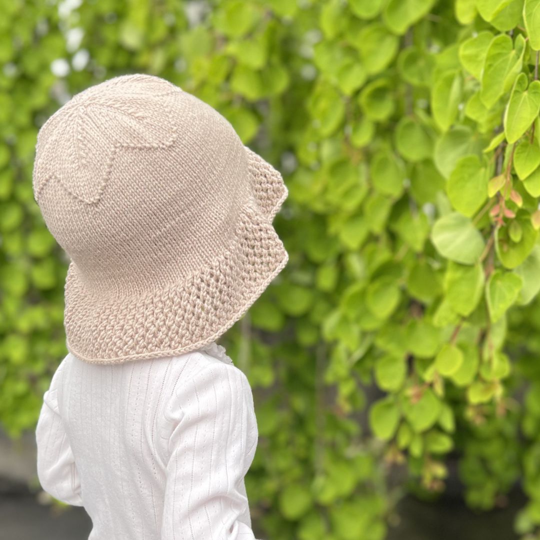 Strikket solhatt bakfra og fra siden – nybegynnervennlig strikkeoppskrift baby og barn