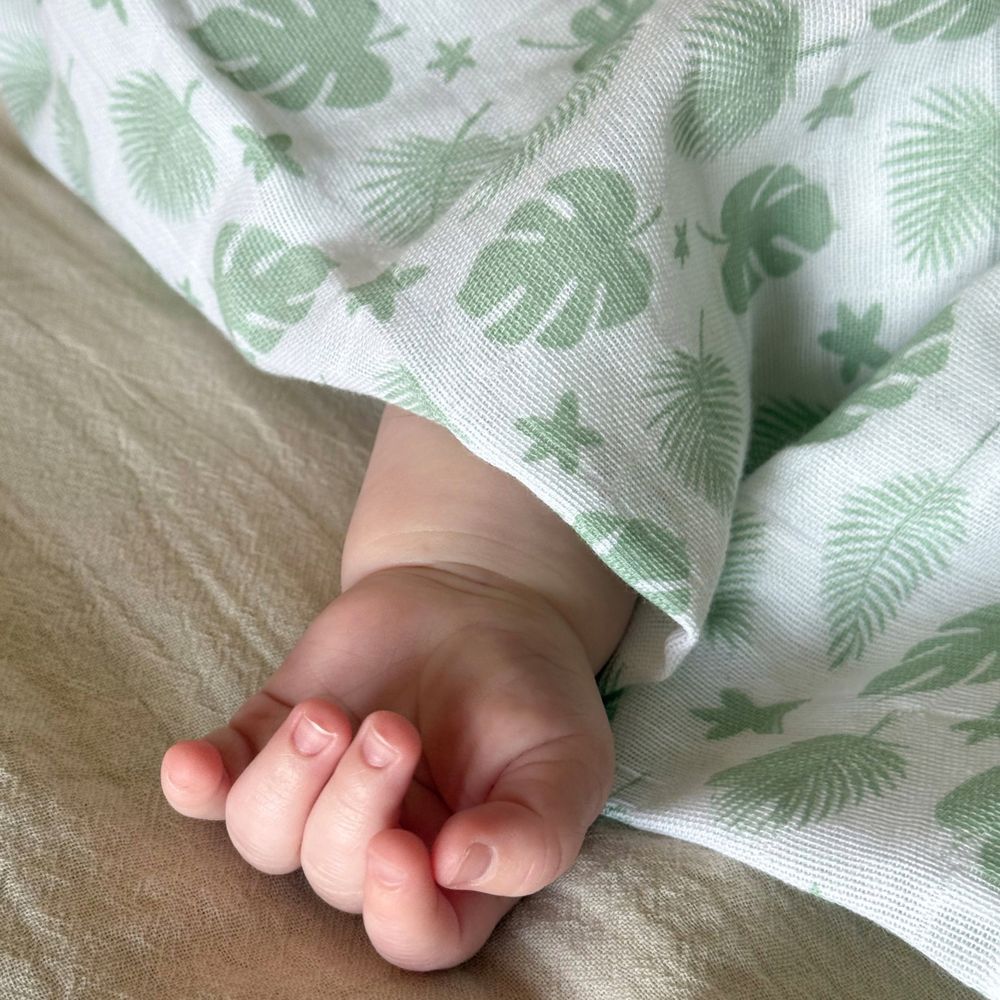 Babypledd, gulpeklut, koseklut fra Summerville Organic i grønn og hvit flerfarget/mønstret i bruk - pleddet ligger over et barn