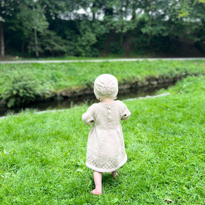 Jente 1 år i Vesleskattens søte kjole og kyse, strikkepakke Dale Garn Soft Merino, kjolen og kysen bakfra