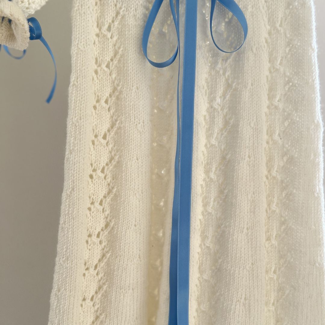 Strikket dåpskjole med blått silkebånd – strikkepakke dåpskjole der du kan velge mellom silkebånd og strikket bånd. Tradisjonell strikke dåpskjole med silkebånd uten knapper, med knytting i nakken for enkel av- og påkledning.