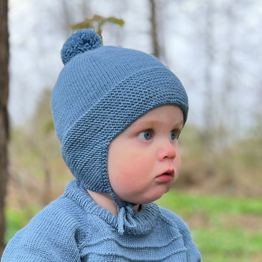 Strikke lue til barn med ørelapper og dusk – strikkepakke drømmelue i 100% kløfri merinoull. Den beste lua for små barn med knyttesnor og ekstra tykt rundt ørene – perfekt for barnehage og aktive barn. Nybegynnervennlig babystrikk for høst og vinter.
