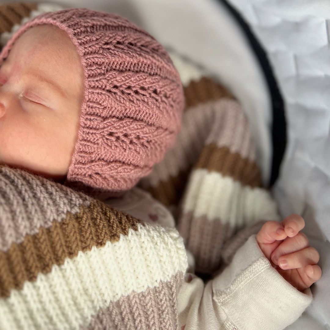 Detaljer på hullmønster på strikket kyse til baby – lett og luftig babylue i 100% kløfri merinoull. Strikke kyse med hullmønster som beskytter mot UV-stråler – perfekt strikkepakke lue til vår og sommer. Strikke lue til baby fra nyfødt til 2–3 år i flere farger.