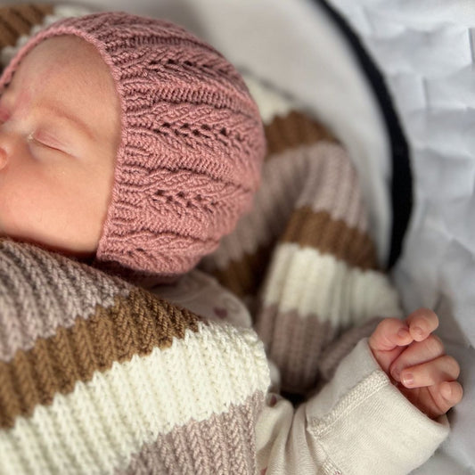 Detaljer på hullmønster på strikket kyse til baby – lett og luftig babylue i 100% kløfri merinoull. Strikke kyse med hullmønster som beskytter mot UV-stråler – perfekt strikkepakke lue til vår og sommer. Strikke lue til baby fra nyfødt til 2–3 år i flere farger.