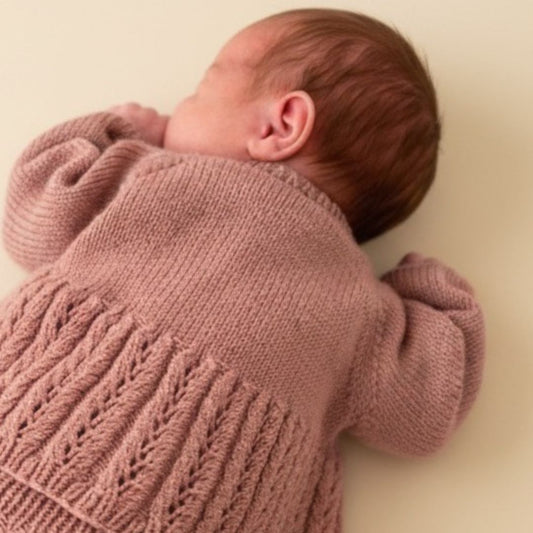 Nærbilde av hullmønster – strikke hentesett med hullmønster til baby i kløfri merinoull. Strikke hentesett selv med vakre detaljer i Dale Garn Soft Merino. Strikkepakke hentesett til jente i 100% merinoull.
