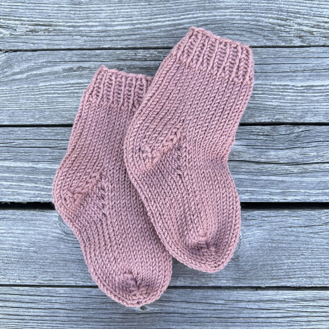 Strikke hentesett med sokker til baby – ullsokker som del av strikkepakke hentesett i kløfri merinoull. Strikke hentesett selv med sokker til nyfødt i Dale Garn Soft Merino. Strikke komplett hentesett til jente i 100% merinoull.