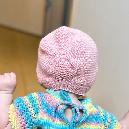 Vesleskattens rillekyse bakfra – babylue i 100% merinoull som ikke klør. Nybegynnervennlig og rask å strikke til baby eller nyfødt. Praktisk kyse i flere farger å velge mellom.