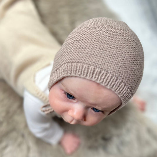 Vesleskattens rillekyse ovenfra – babylue i 100% merinoull som ikke klør. Nybegynnervennlig og rask å strikke til baby eller nyfødt. Praktisk kyse i flere farger å velge mellom.