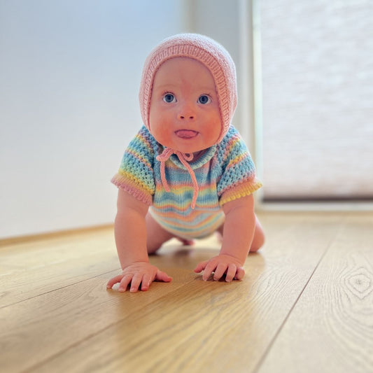Vesleskattens rillekyse på baby som kryper – praktisk kyse i 100% merinoull som ikke klør. Nybegynnervennlig babystrikk, rask å strikke til nyfødt. Flere farger å velge mellom.