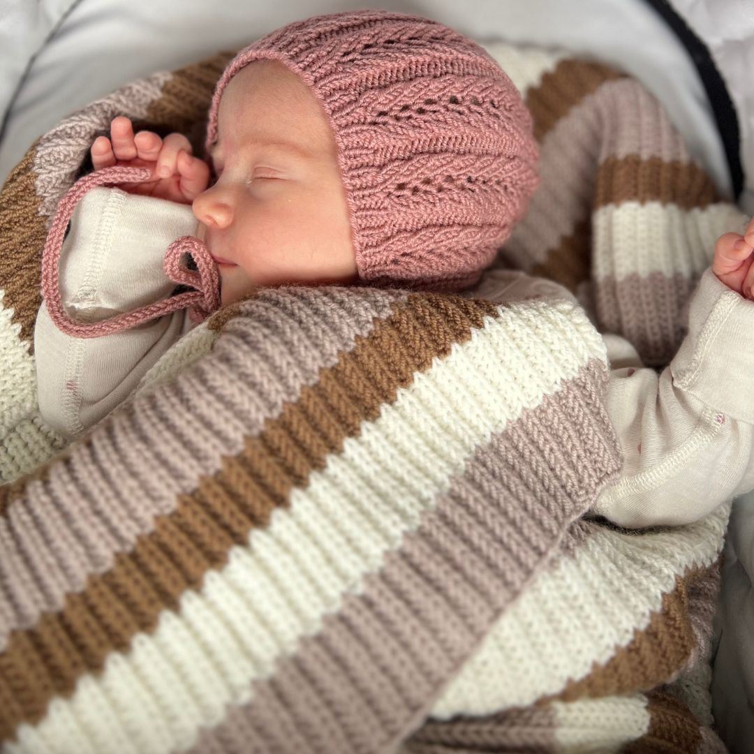 Vesleskattens yndlingspledd brukt som vognteppe – babypledd i 100% kløfri merinoull med halvpatent. Nybegynnervennlig strikkepakke babystrikk, lett å strikke. Perfekt som babyens første teppe eller teppe til hentesett.