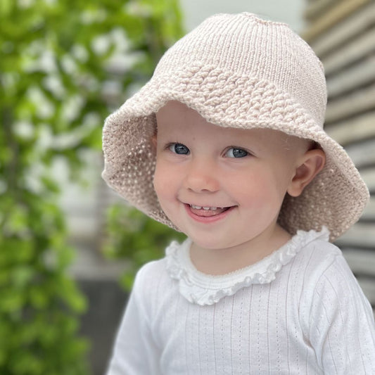 Smilende barn med strikket solhatt – nybegynnervennlig strikkeoppskrift baby og barn